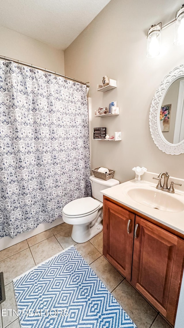 bathroom featuring toilet, tile patterned flooring, and vanity