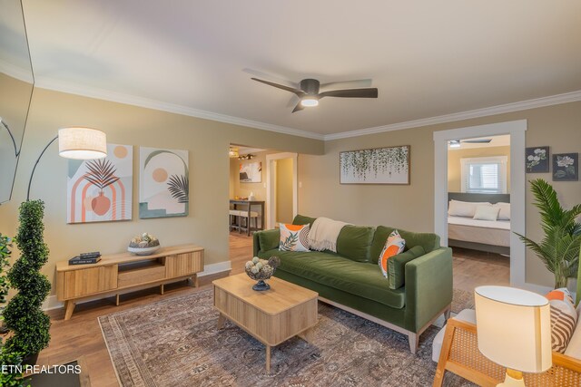 living room with hardwood / wood-style flooring, ornamental molding, and ceiling fan