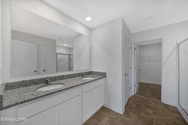 bathroom featuring walk in shower and vanity