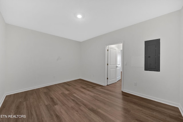 empty room featuring electric panel and dark hardwood / wood-style floors