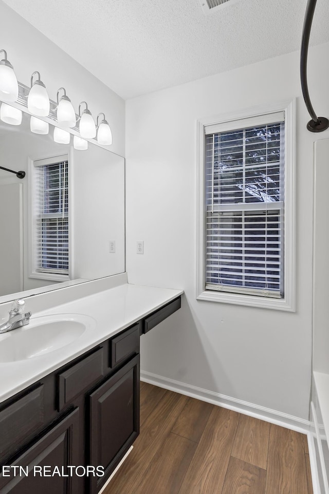 bathroom featuring hardwood / wood-style floors, vanity, and a textured ceiling