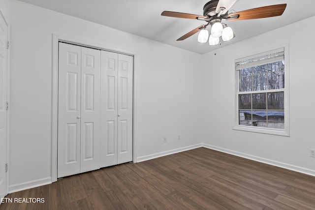 unfurnished bedroom with ceiling fan, dark hardwood / wood-style flooring, and a closet