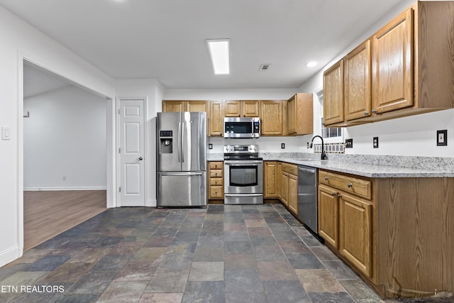 kitchen featuring light stone countertops, sink, and appliances with stainless steel finishes