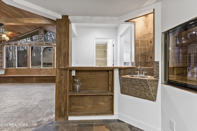 bar with wood ceiling, ceiling fan, sink, and lofted ceiling with beams