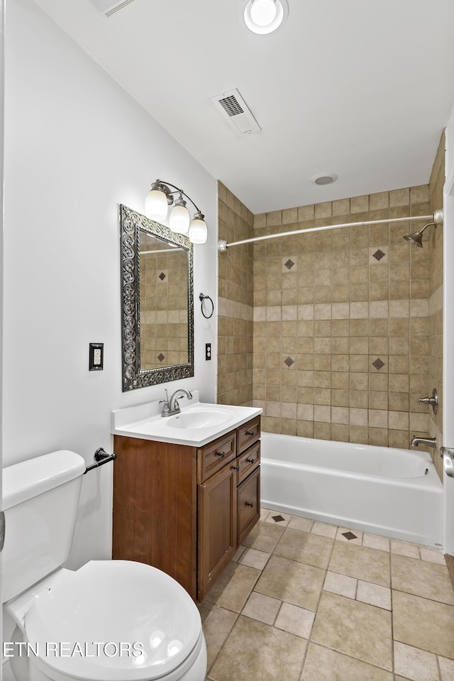 full bathroom with toilet, vanity, and tiled shower / bath