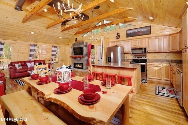 dining area featuring a notable chandelier, a fireplace, light hardwood / wood-style flooring, and wooden ceiling