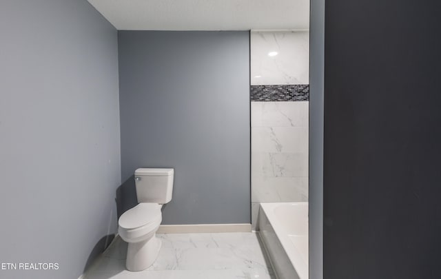 bathroom with a bathtub, toilet, and a textured ceiling