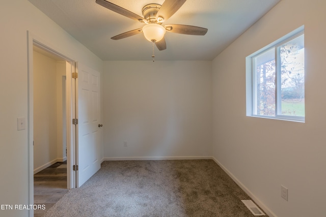 carpeted empty room featuring ceiling fan