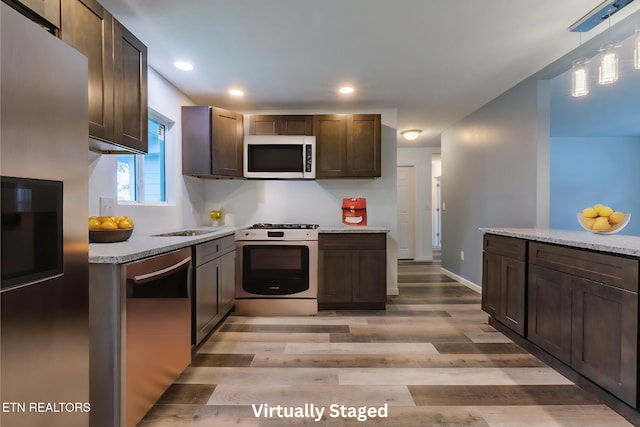 kitchen with gas range gas stove, decorative light fixtures, dark brown cabinets, light hardwood / wood-style flooring, and dishwasher