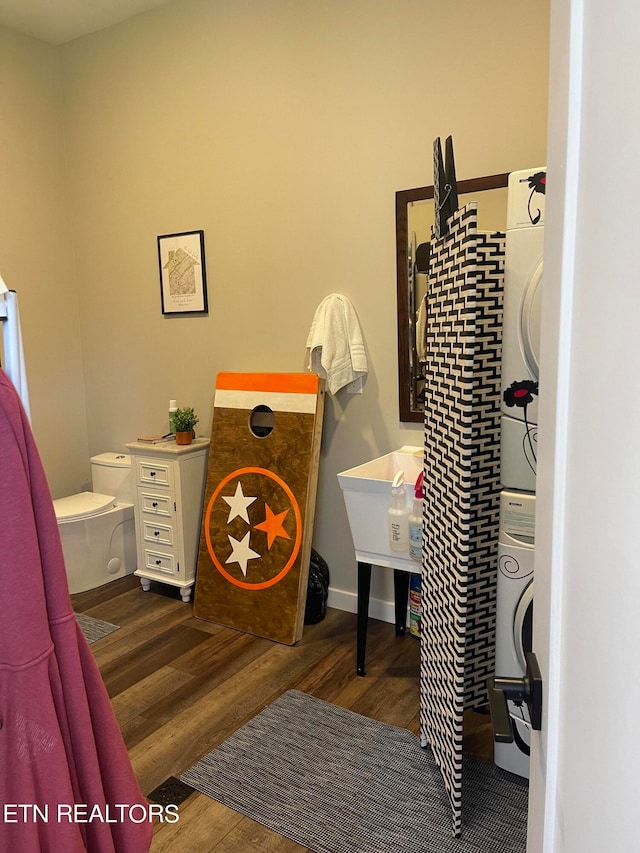 interior space featuring dark hardwood / wood-style flooring and stacked washer / dryer