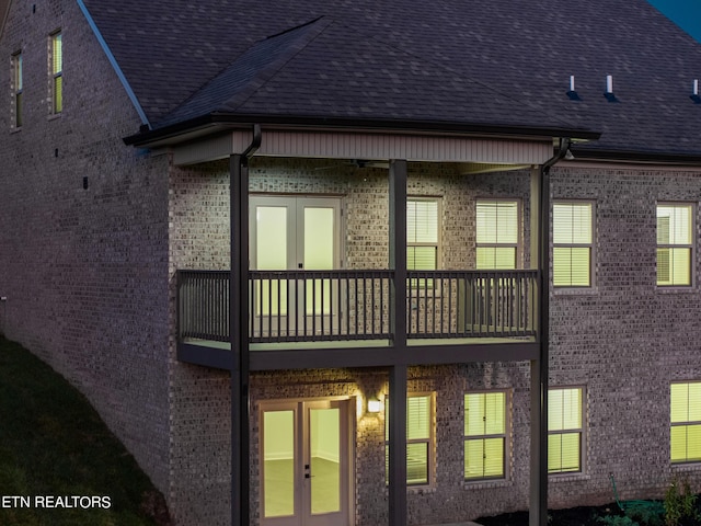 back of house with french doors and a balcony