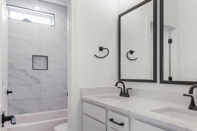 full bathroom featuring vanity, toilet, and tiled shower / bath