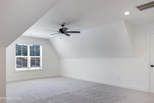 additional living space with ceiling fan, vaulted ceiling, and light carpet