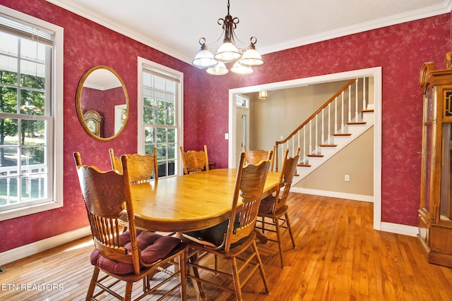 dining room with an inviting chandelier, ornamental molding, and hardwood / wood-style flooring