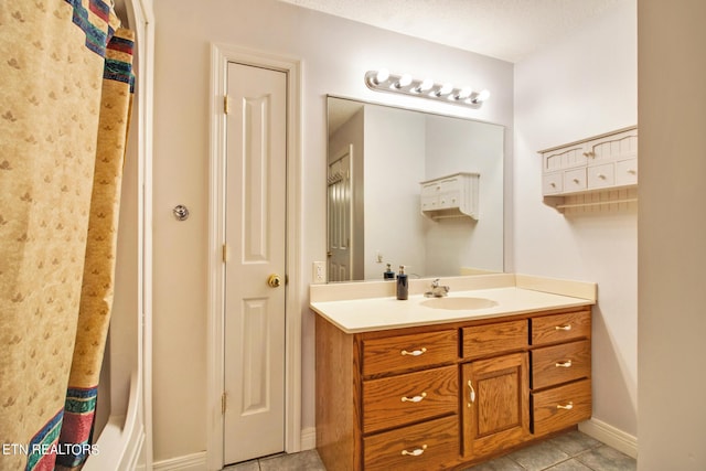 bathroom with a textured ceiling, tile patterned floors, and vanity