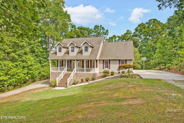 new england style home with covered porch and a front lawn