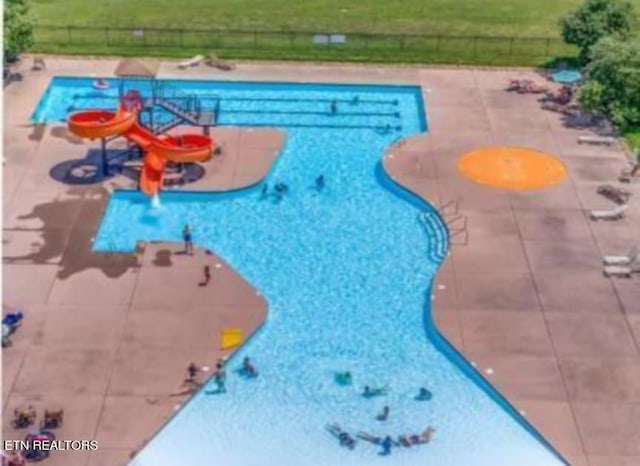 view of swimming pool featuring a yard and a patio area