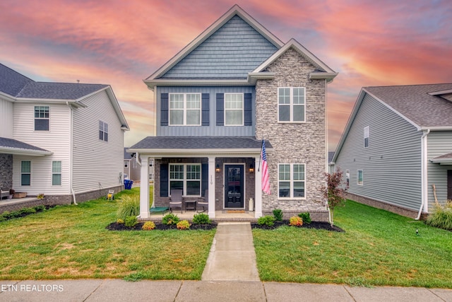 view of front of house with a porch and a yard