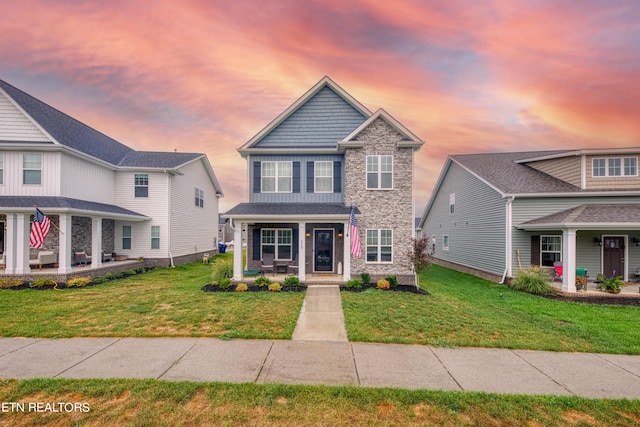 view of front of property with a porch and a lawn