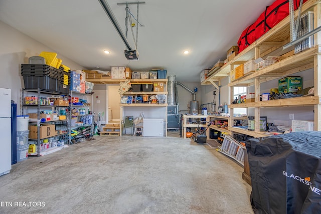 garage with a garage door opener, white refrigerator, and a workshop area