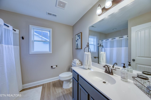 bathroom with wood-type flooring, toilet, a shower with shower curtain, and vanity