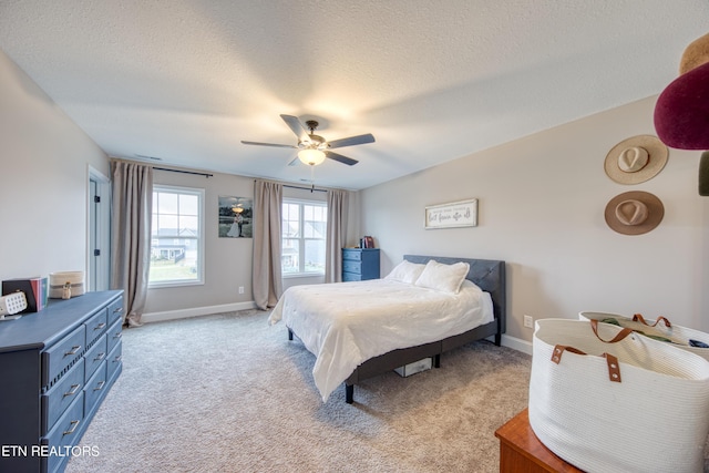 carpeted bedroom featuring a textured ceiling and ceiling fan