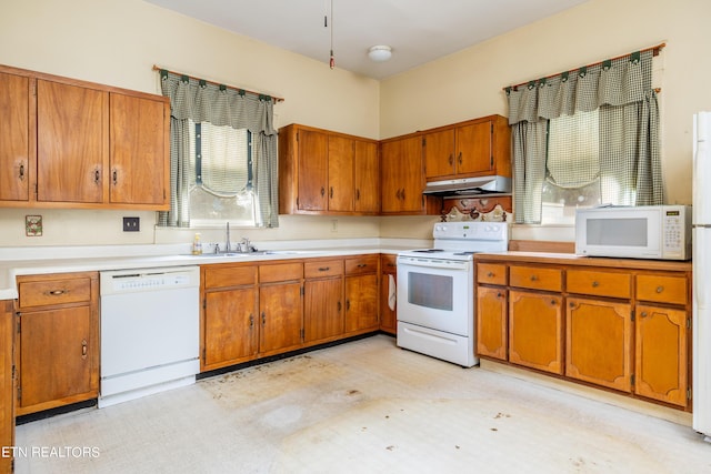 1227 N Main St, Sweetwater, TN 37874 - kitchen with under cabinet range hood, a sink, brown cabinetry, and white appliances