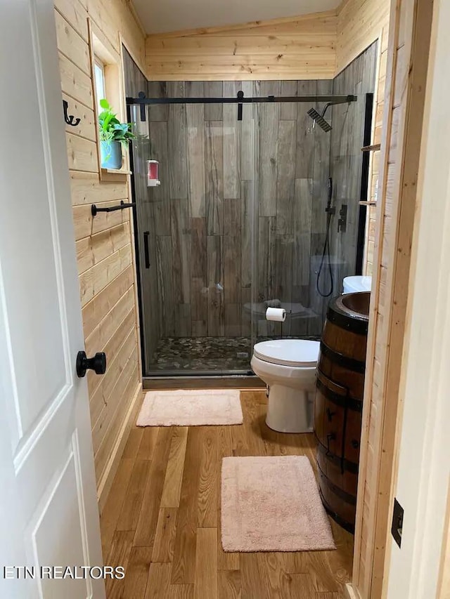 bathroom featuring a shower with door, vanity, hardwood / wood-style floors, and toilet