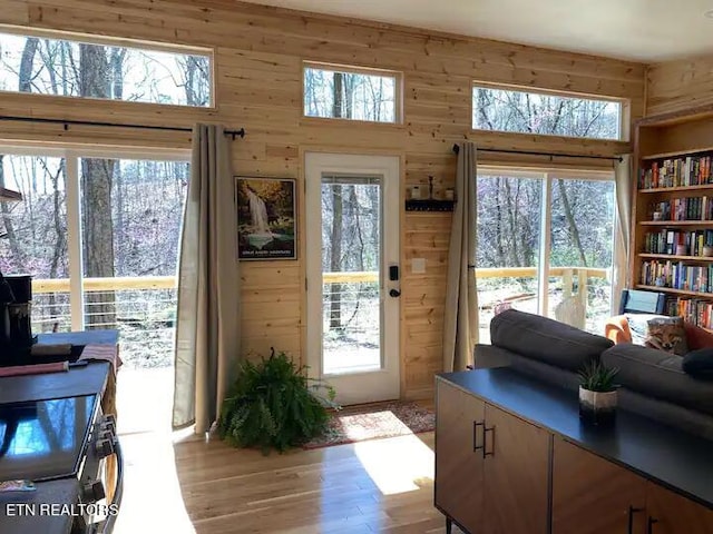 entryway featuring a wealth of natural light, light hardwood / wood-style floors, and wood walls