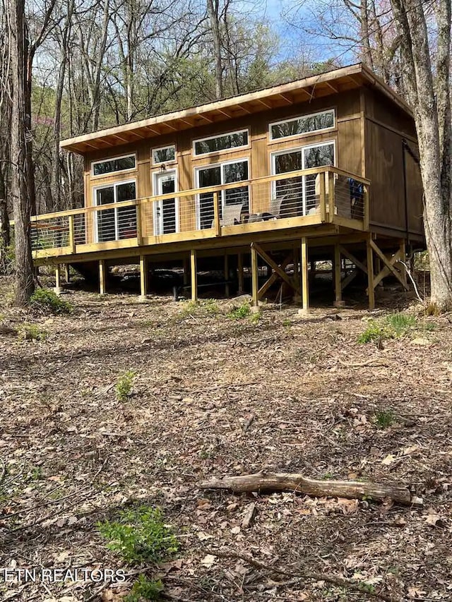 rear view of property featuring a wooden deck