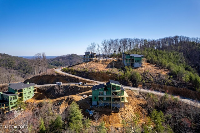 birds eye view of property featuring a wooded view and a mountain view