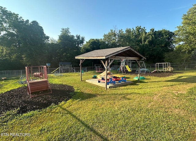 view of yard featuring playground community and fence