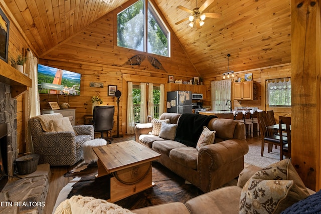 living room with high vaulted ceiling, ceiling fan, wood ceiling, and wooden walls