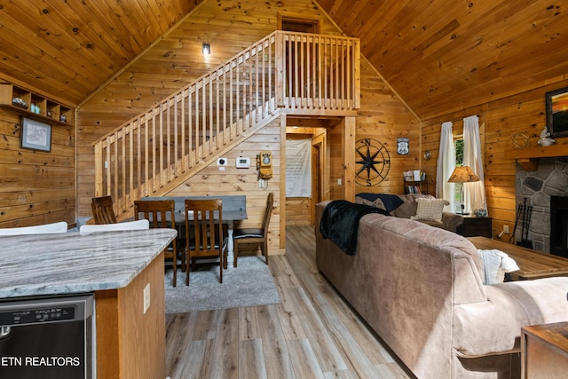 living room featuring vaulted ceiling, wood ceiling, light hardwood / wood-style floors, and wood walls