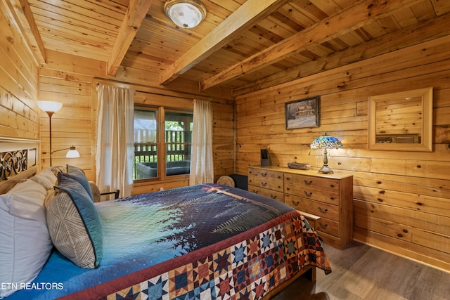 bedroom with beam ceiling, dark hardwood / wood-style floors, wood ceiling, and wood walls