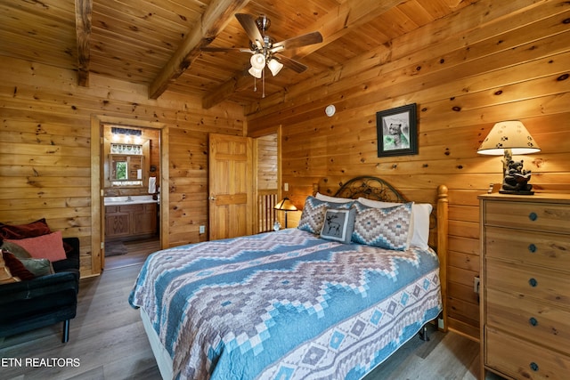 bedroom with ceiling fan, beam ceiling, dark wood-type flooring, connected bathroom, and wooden ceiling