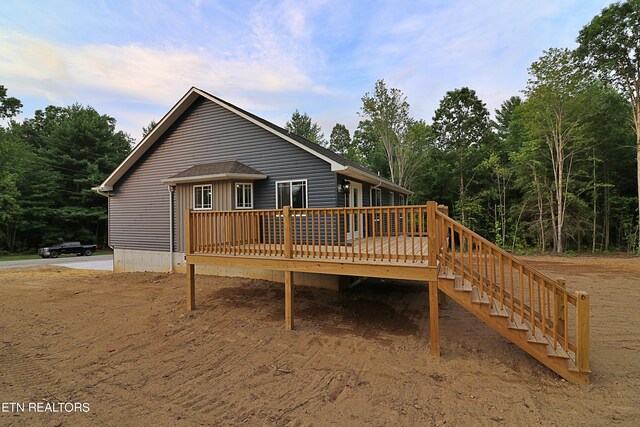 rear view of property featuring a wooden deck