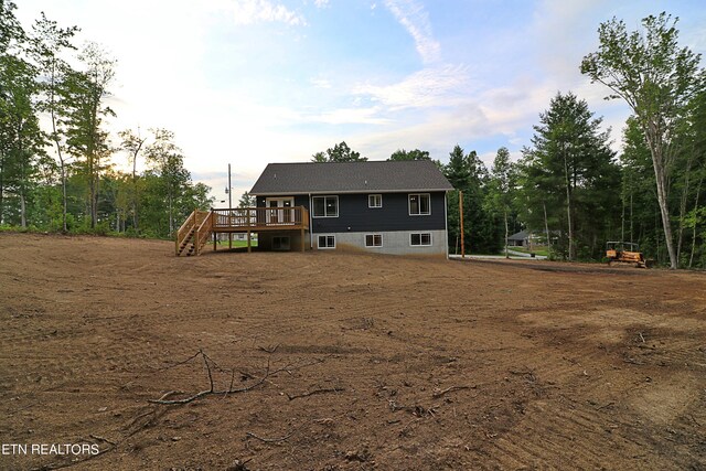 rear view of house featuring a wooden deck