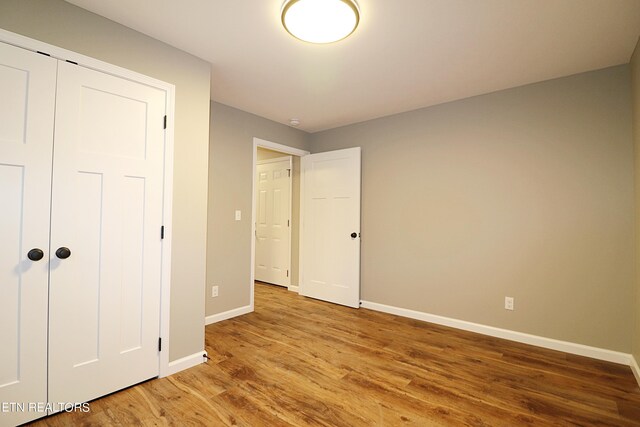 unfurnished bedroom with light hardwood / wood-style floors and a closet