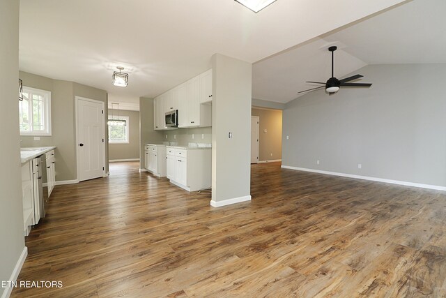 interior space featuring tasteful backsplash, hardwood / wood-style flooring, lofted ceiling, white cabinetry, and ceiling fan