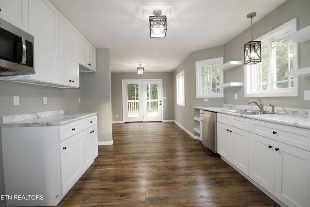 kitchen featuring white cabinets, dark wood-type flooring, stainless steel appliances, light stone countertops, and sink