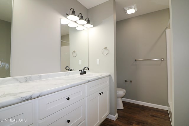 bathroom with hardwood / wood-style floors, vanity, and toilet