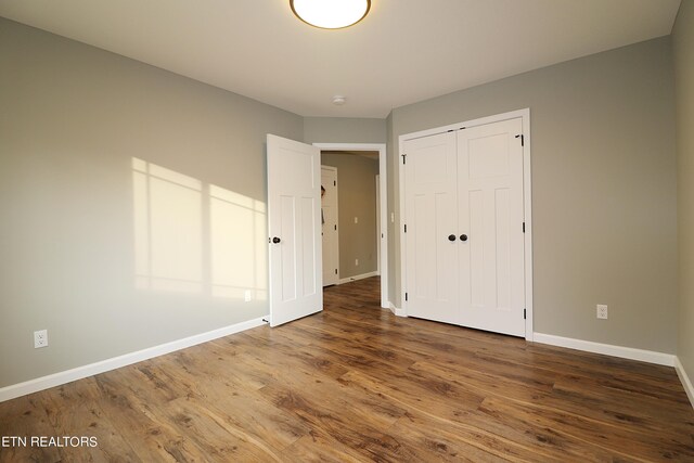 unfurnished bedroom with a closet and hardwood / wood-style flooring