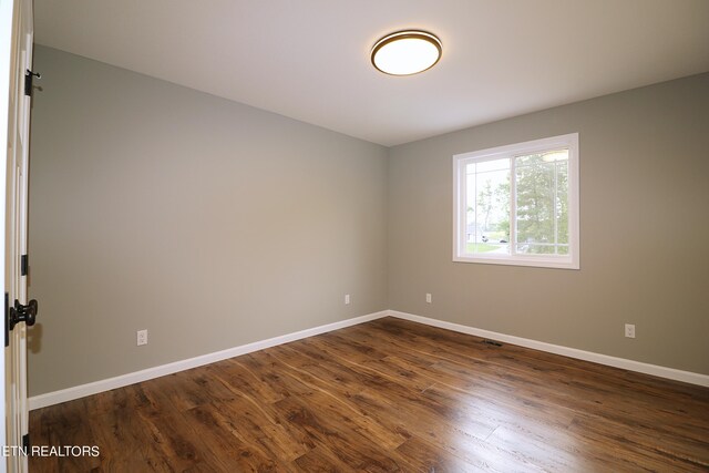 unfurnished room featuring dark hardwood / wood-style floors