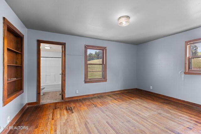 unfurnished bedroom featuring tile patterned flooring and connected bathroom