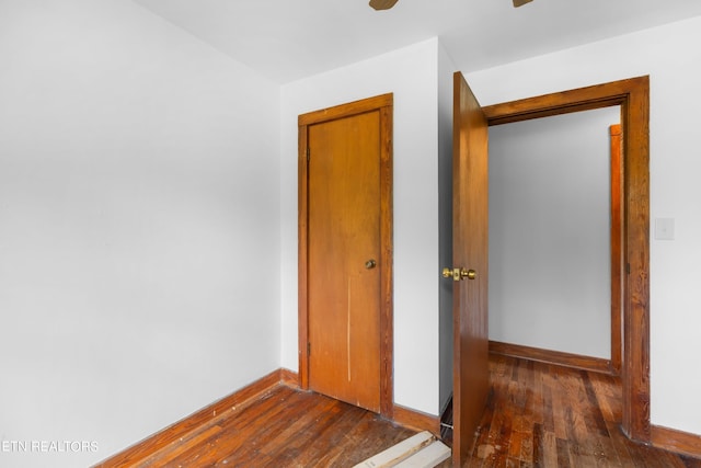 unfurnished bedroom featuring ceiling fan and dark hardwood / wood-style flooring