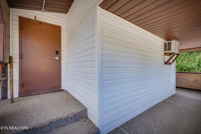 property entrance featuring a wall mounted air conditioner and a patio