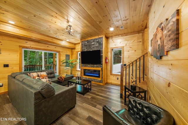 living room with wood ceiling, dark wood-type flooring, a stone fireplace, and wood walls