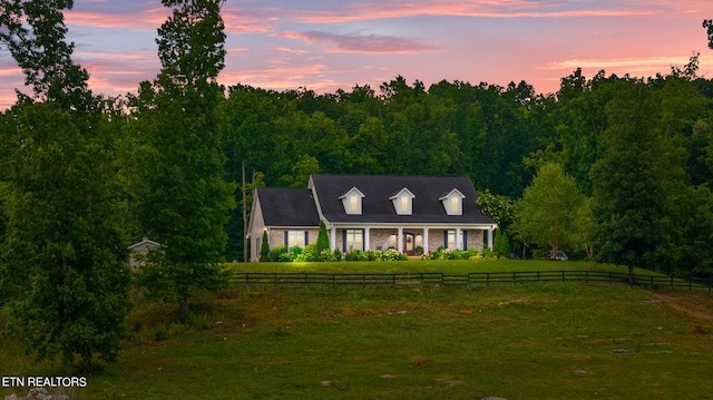 cape cod home with a yard