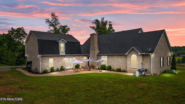 view of front of house featuring a patio and a lawn